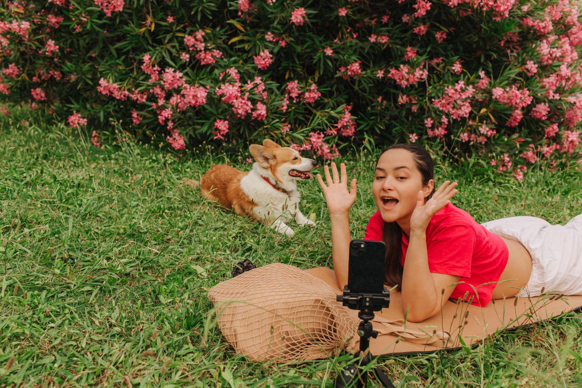 Creator recording content outdoors with a dog beside them, illustrating natural brand personality supported by only fans managers.
